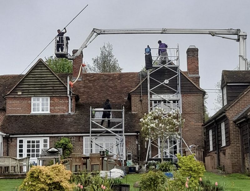 The Moss Cleaners using cherry picker and scaffolding to clean roof safely and professionally in Liphook, Hampshire